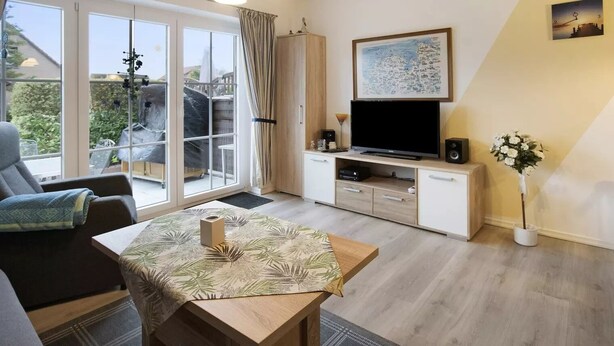 A modern living room with a sofa, a dining table, a TV, and a balcony with curtains.