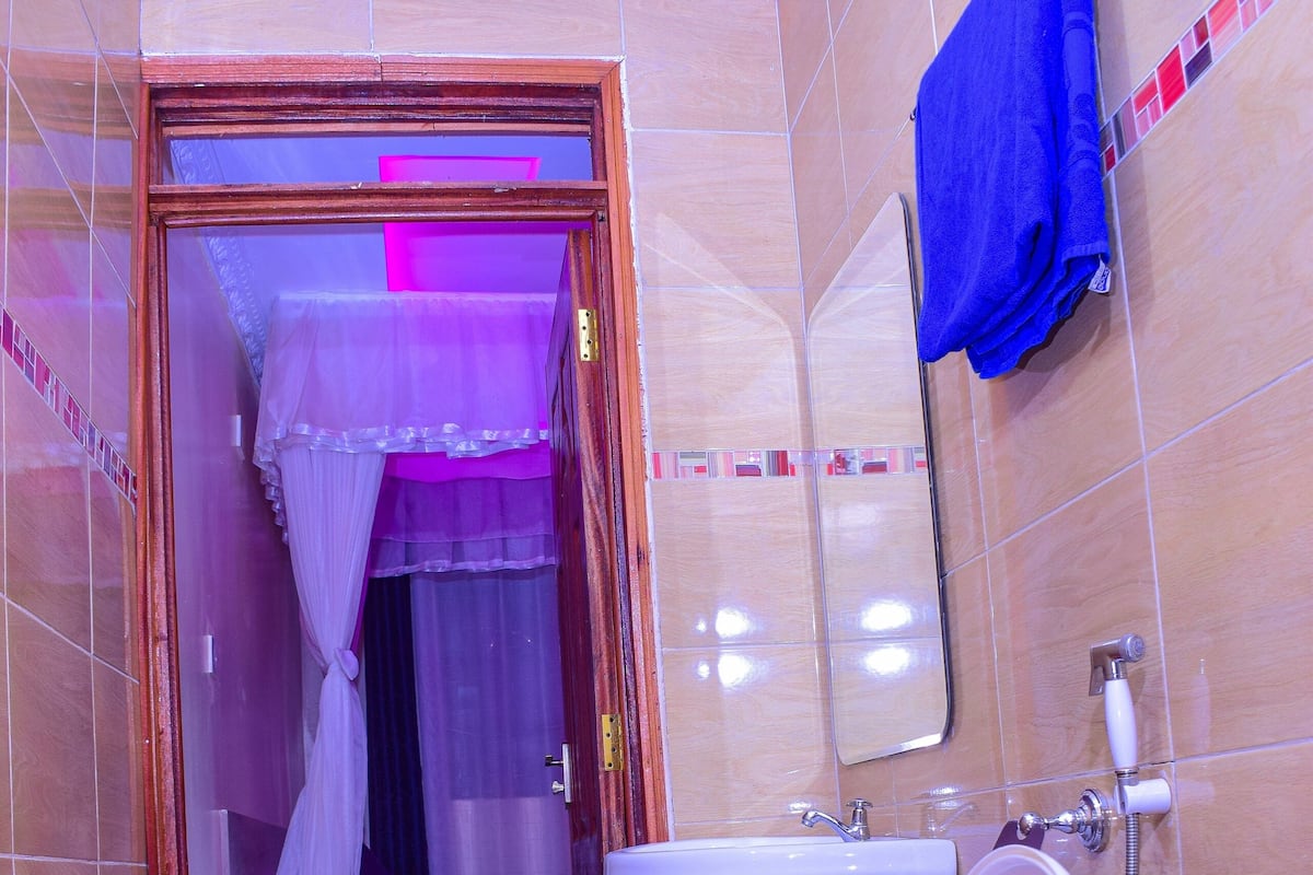 A bathroom with a toilet, sink, and shower area.