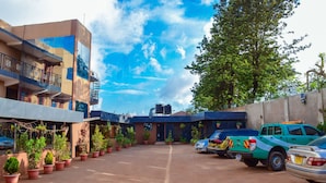 A parking area with a building, potted plants, and a green pickup truck.