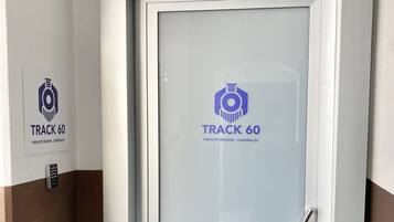 Uma porta com painel de vidro jateado e um logotipo com a inscrição 'TRACK 60 PRIVATE ROOMS - GARIBALDI'.