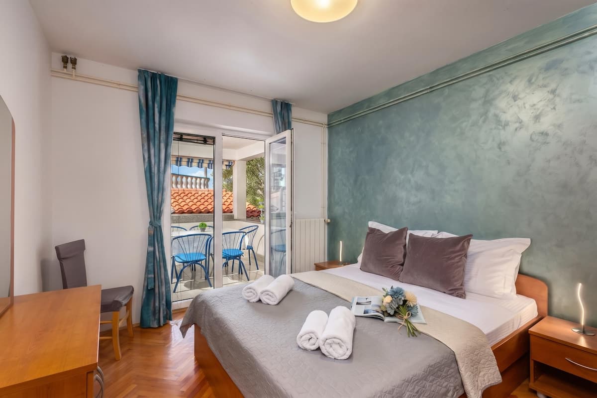 Une chambre à coucher avec un lit, une table de chevet et une vue sur l’extérieur.