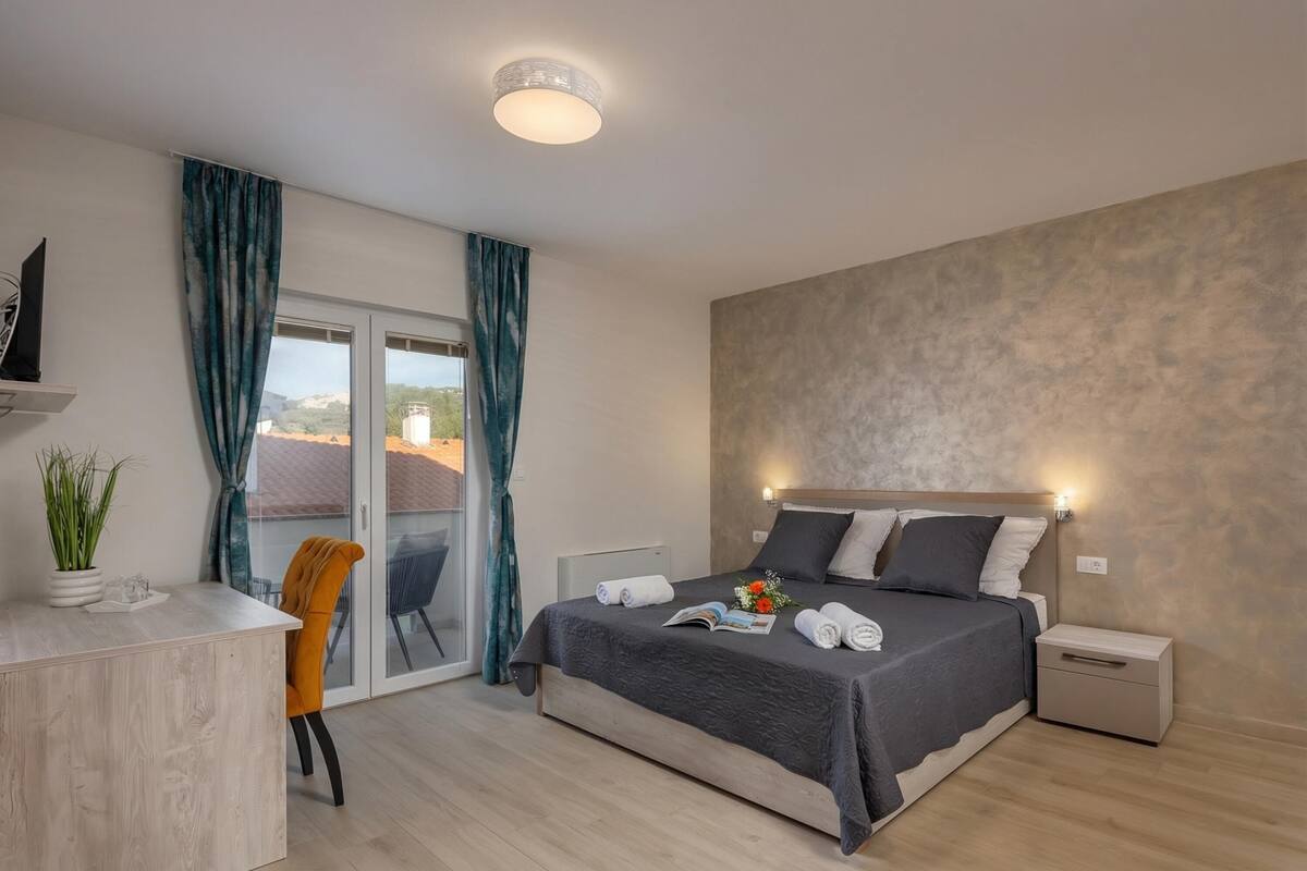 Une chambre d’hôtel moderne équipée d’un lit, d’une table de chevet et d’un bureau avec une chaise.