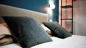 A neatly made bed with multiple pillows and a headboard. - QUEEN 20 - PRIVATE ROOMS DUOMO (Naples)