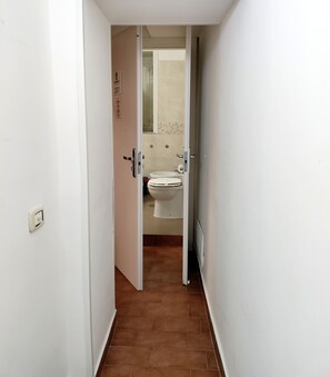 A narrow hallway leading to a bathroom with a toilet and sink. - QUEEN 20 - PRIVATE ROOMS DUOMO (Naples)