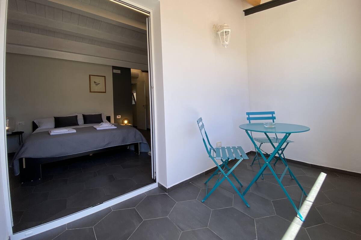 Une pièce comprenant un lit, une petite table avec des chaises et un luminaire fixé au mur.