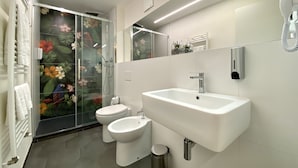 A modern bathroom with a glass shower enclosure, a white sink, and a toilet. - B&B ALIVA (Alcamo)