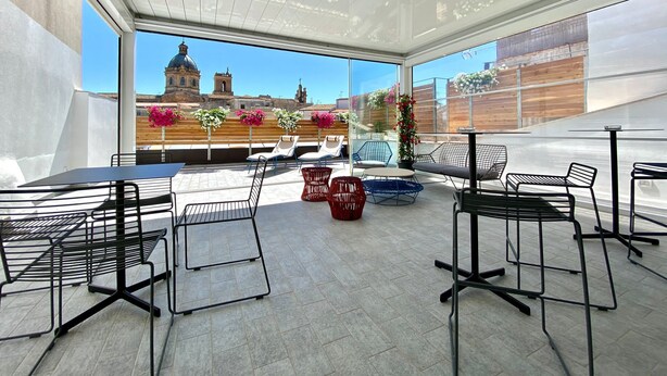 A rooftop terrace with outdoor seating, a view of a historic building, and potted plants. - B&B ALIVA (Alcamo)
