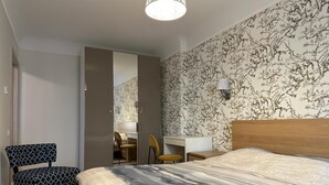Ein Schlafzimmer mit Bett, Schreibtisch, Stuhl und Kleiderschrank.