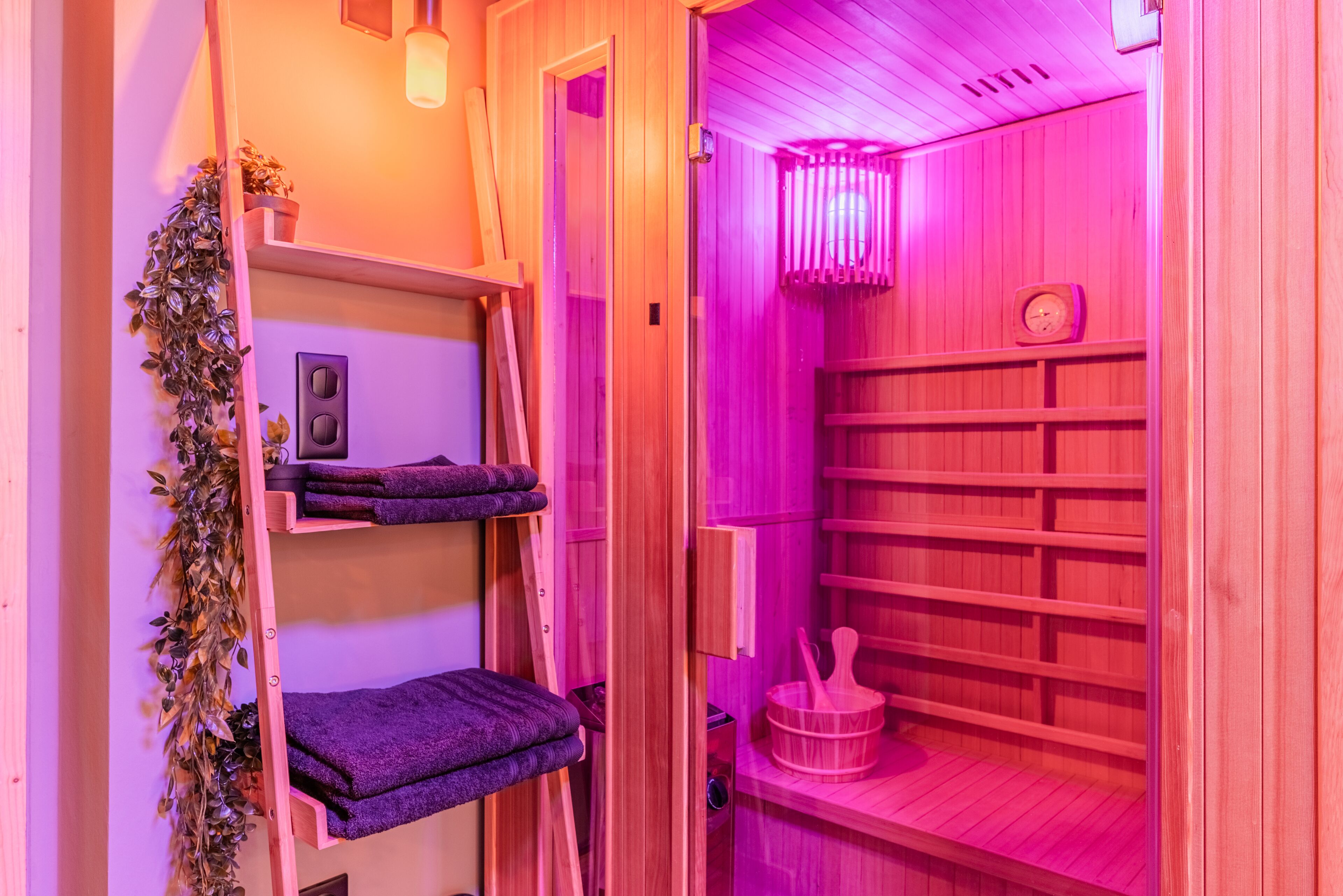 Un sauna en bois, avec des étagères pour ranger les serviettes et un seau.