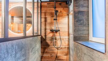 A modern shower with wooden paneling and a glass enclosure.