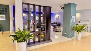 A modern hotel lobby with a reception desk, seating area, and a decorative plant display. - The Beach INN Cha-Am (Cha-am)