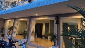 A multi-story hotel with balconies, a sign indicating it's The Beach Inn, and potted plants outside. - The Beach INN Cha-Am (Cha-am)