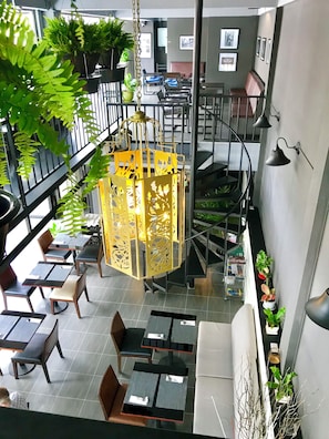 A multi-level restaurant with outdoor seating, a central hanging lantern, and potted plants. - The Beach INN Cha-Am (Cha-am)