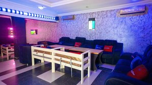 A modern lounge area with a sofa set, a small table, and a TV screen. - Royalty Place Hotel (Lagos)