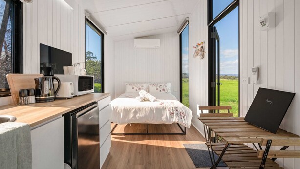 A modern bedroom with a bed, a desk, and a laptop. - Bush Retreat 2 by Tiny Away (Alberton West)