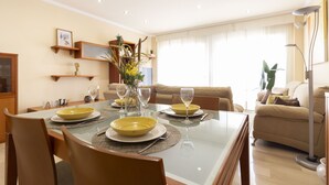 A dining area with a glass table, yellow plates, and a vase with flowers. - Casa cerca BCN,  ideal empresas, 15min FiraBCN, A/C (Sant Boi de Llobregat)