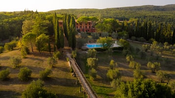 Escape to a serene retreat surrounded by lush greenery and rolling hills, with a tranquil pool and peaceful atmosphere.