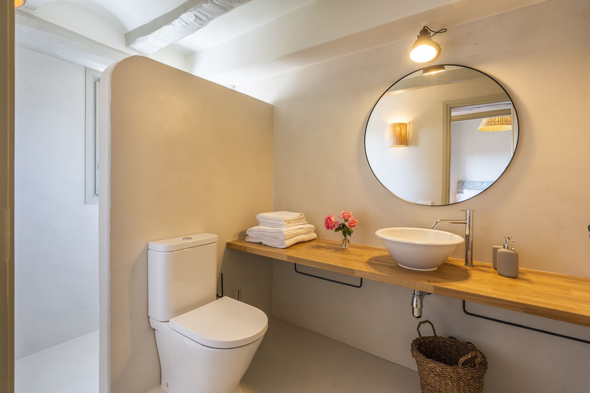 A modern bathroom with a toilet, sink, and mirror.
