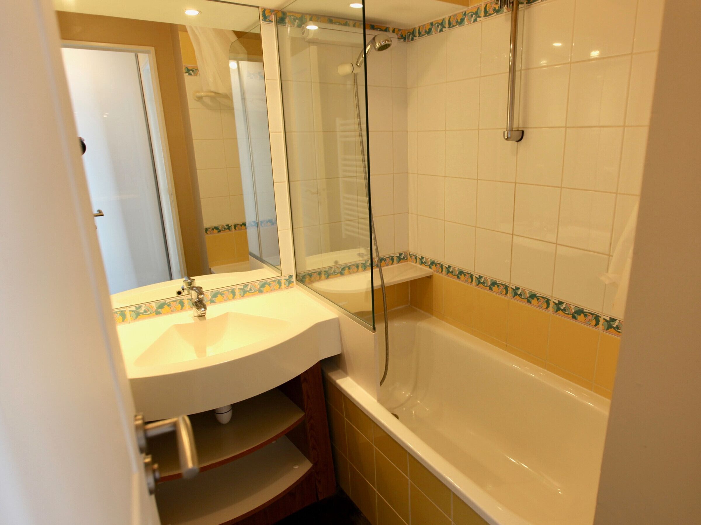 Une salle de bain avec un lavabo, un miroir et une baignoire.
