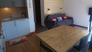 Ein gemütlicher Wohnraum mit Küchenzeile, Esstisch und Sofa.