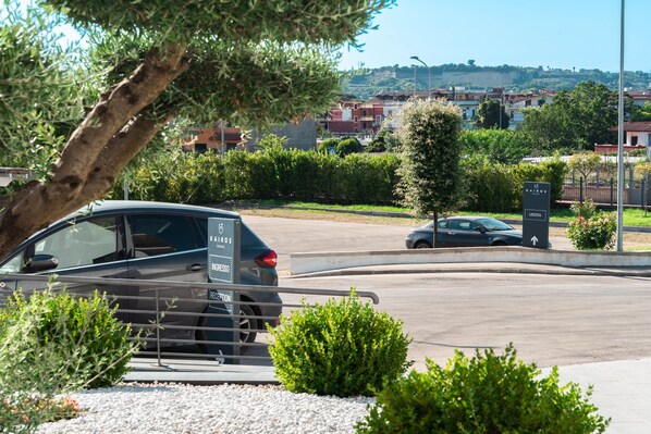 Un espace de stationnement avec une voiture et un panneau indiquant une direction.