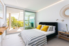 Une chambre à coucher moderne avec un grand lit, une porte vitrée donnant sur un balcon et un design minimaliste.