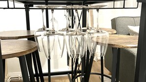 Une table à manger agrémentée d’une plante en pot, de verres transparents et de pieds en métal noir.