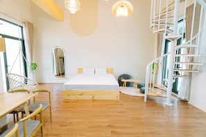 Un dormitorio moderno con cama de madera, una escalera de caracol y un comedor con mesa y sillas.