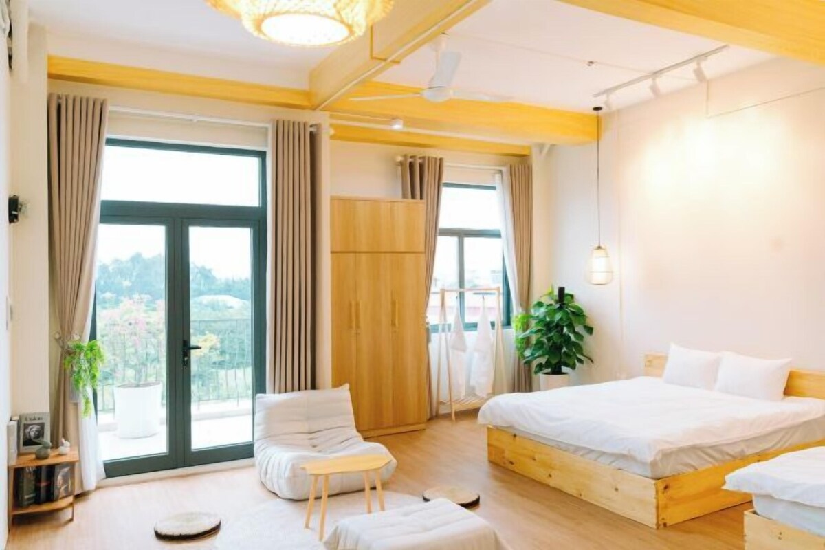 Un dormitorio moderno con una cama grande, un pequeño rincón de descanso y vistas al exterior.