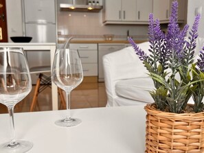 Una mesa de comedor con dos copas de vino vacías y una cesta de mimbre con plantas de lavanda.