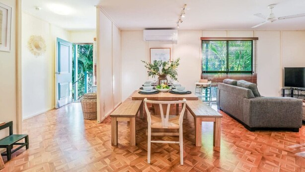 Un'ampia zona giorno con tavolo da pranzo, divano e televisore.