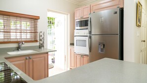 A kitchen with a stainless steel refrigerator, double ovens, and a microwave. - Cityscape Living at Surbiton (Kingston)