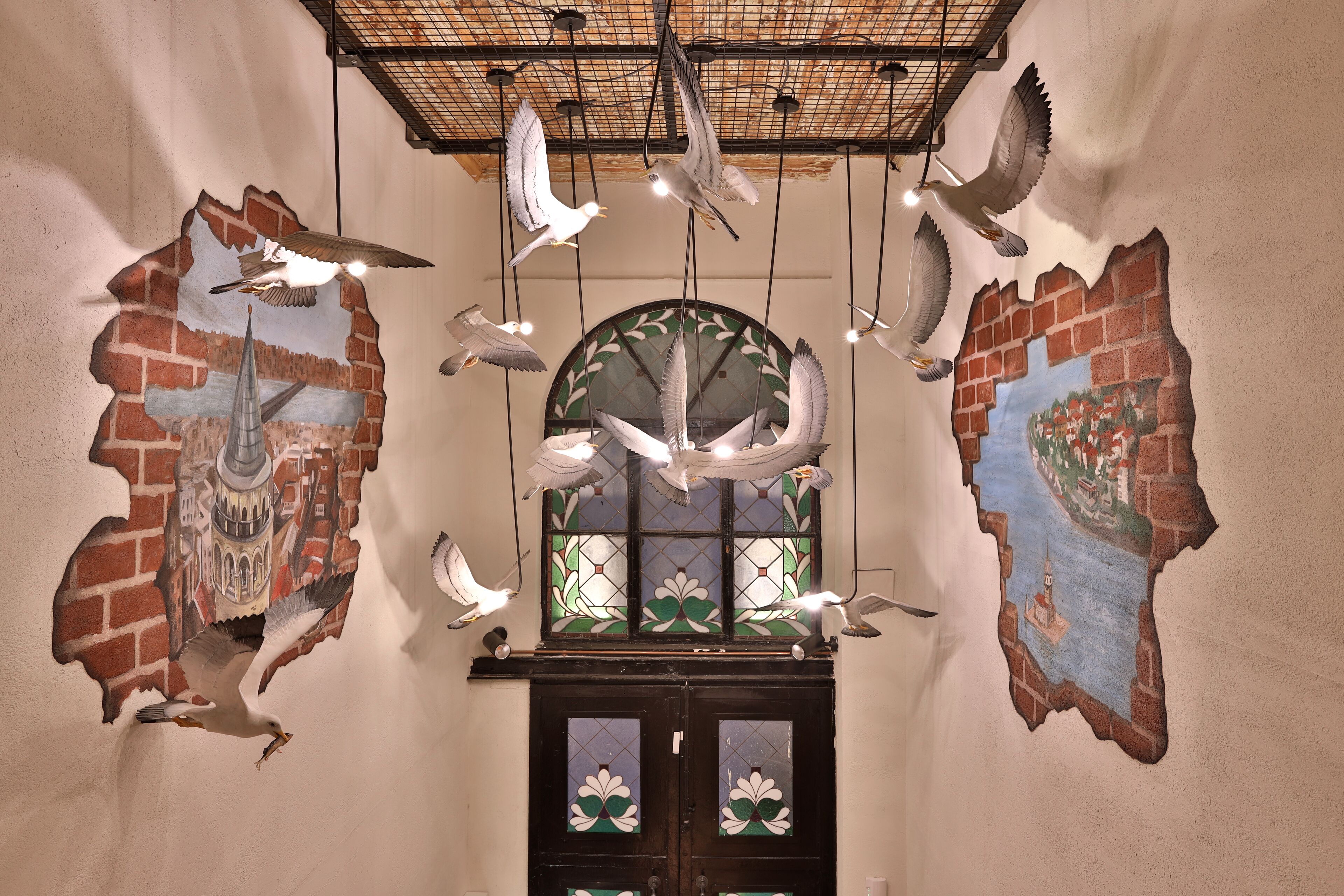 A wall with a stained glass window and a door with decorative glass panels.