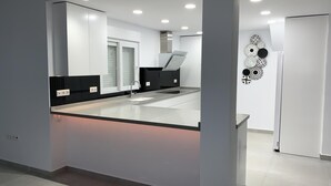 A modern kitchen with a central island, recessed lighting, and a black countertop. - Modern 3 Bed Villa - Golf Side, Own Pool, sleeps 6, Mar Menor Golf Resort     (Torre-Pacheco)