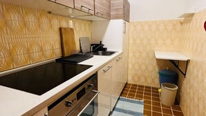 Une cuisine de taille réduite, équipée d’une cuisinière, d’un four et d’un évier.