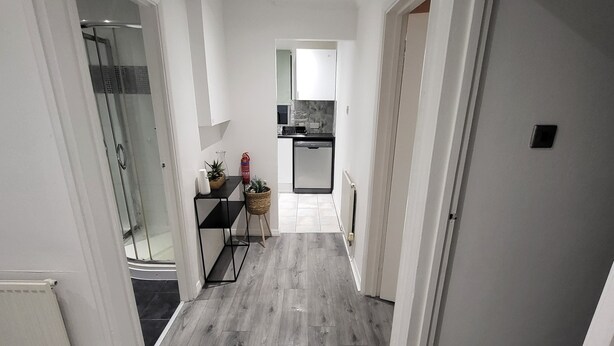 A modern apartment with a kitchen, a dining area, and a shower. - Charming 2-bed Apartment in Grays (Grays)
