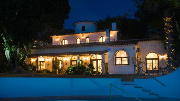 A two-story house with a swimming pool, featuring a light-colored exterior, arched windows, and a staircase leading to the upper floor. - Exceptional private villa with sea view & heated pool (Mijas)