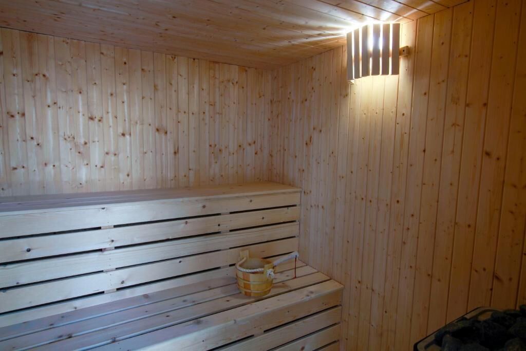 Un cuarto de sauna con bancos de madera y una pared de madera.