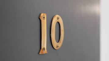 A wooden number '10' mounted on a grey wall.