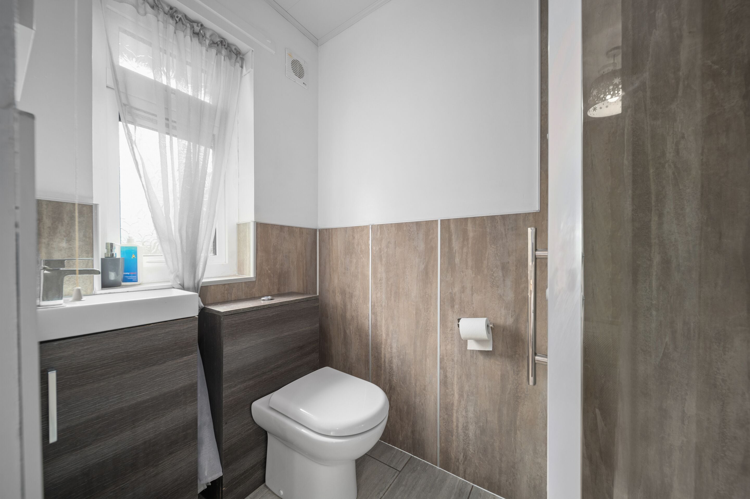 A modern bathroom with a toilet, sink, and shower area.