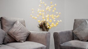 A room with two grey upholstered chairs and a vase with yellow flowers and peacock feathers. - Queensferry guest house (Dunfermline)