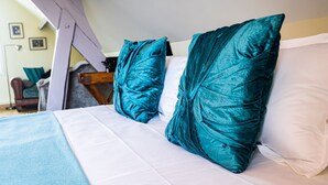 A bed with teal pillows and a white comforter. - 23   (Soulac-sur-Mer)