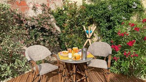 A wooden deck with wicker chairs and a round table set for breakfast. - 23   (Soulac-sur-Mer)