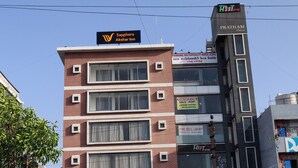A multi-story building with signage for 'Sapphire Akshar Inn' and 'Hostel'.