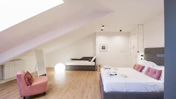 Un dormitorio moderno con una cama grande, un sofá y un tragaluz.