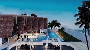 A resort with a pool area, multiple buildings with a modern design, and a view of the beach.