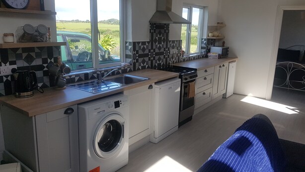Een moderne keuken met een wasmachine, fornuis en een spoelbak.