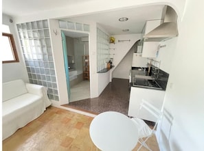 Um espaço compacto com cozinha, área de refeições e banheiro.