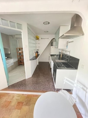 Uma cozinha compacta com fogão, pia e um pequeno espaço para refeições.