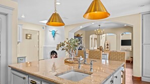 A kitchen with granite countertops, a sink, and a hanging light fixture. - Location, Location!! Unforgettable Sunsets-Balloon Fiesta dream home! (Albuquerque)